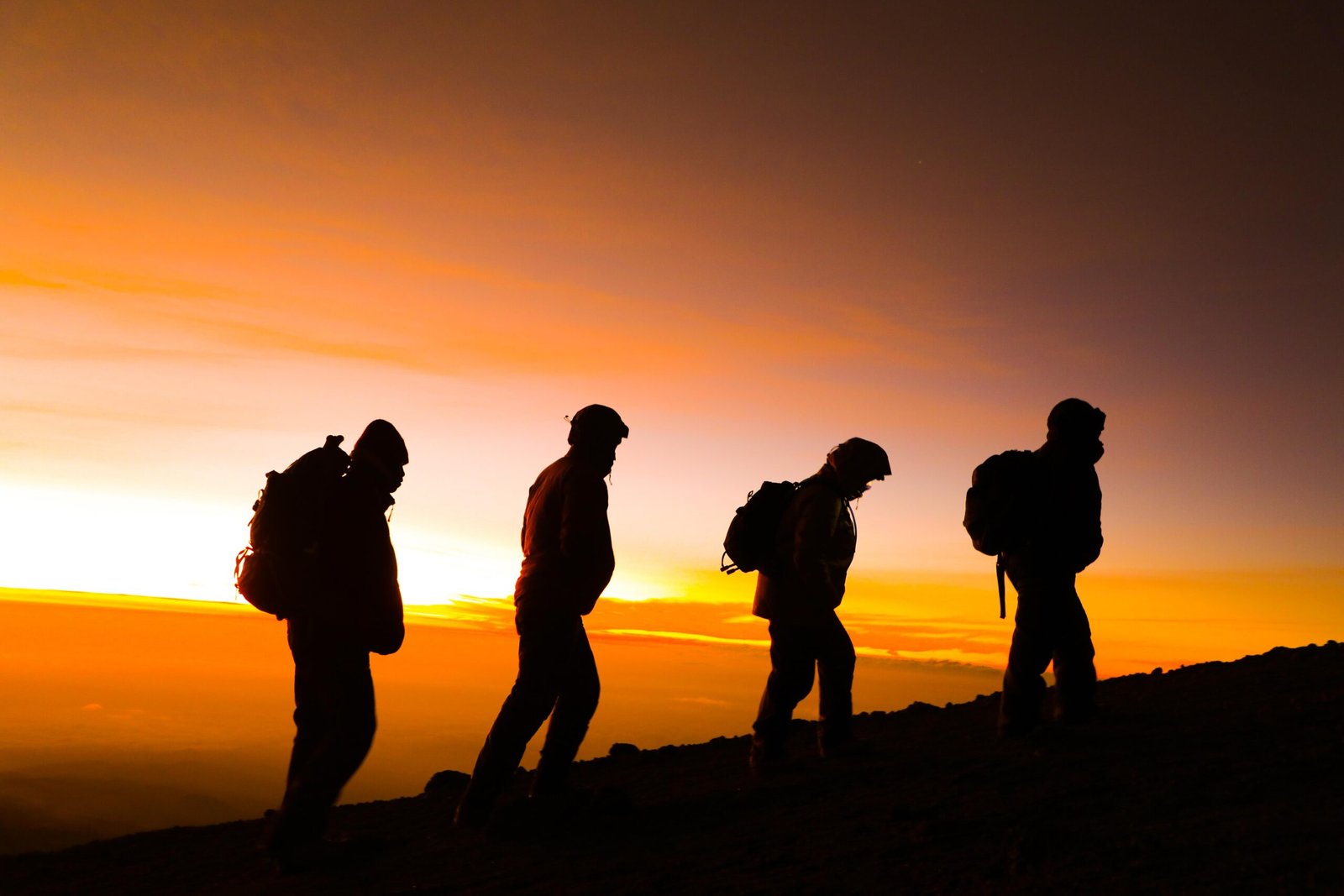Kilimanjaro trekking gear including waterproof jacket, hiking boots, sleeping bag and daypack laid out before a climb